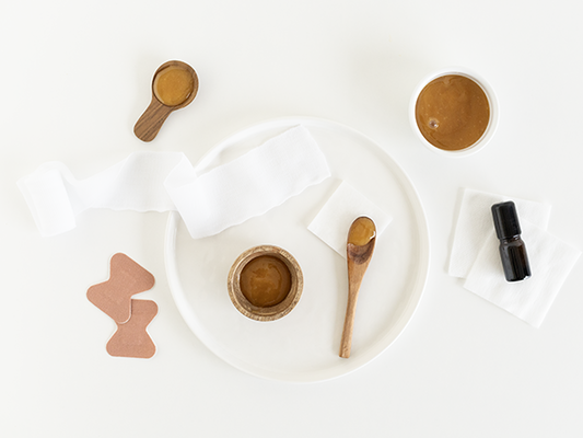 A flat lay of skincare tools and products on a white background.