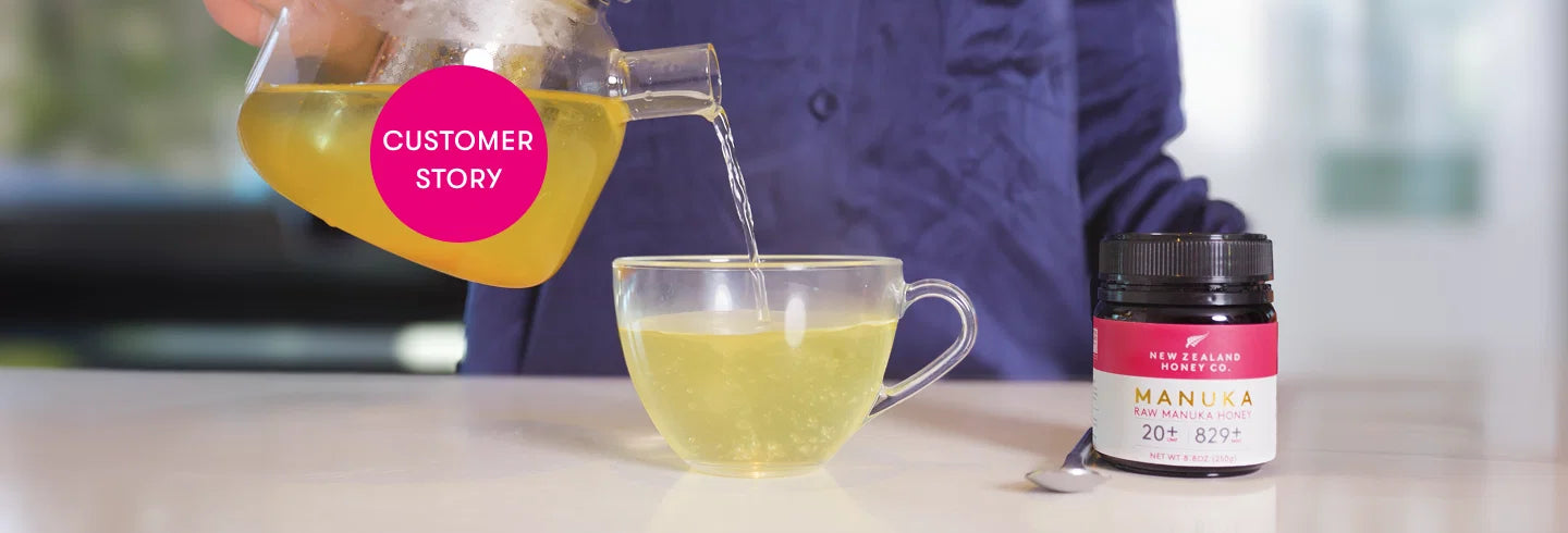 Person pouring golden manuka honey tea from a jar into a clear cup next to a honey jar labeled with customer story badge.