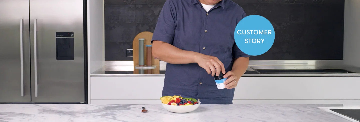 Man in blue shirt standing at modern kitchen counter with bowl of colorful cereal, holding milk carton