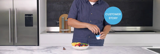 Man in blue shirt standing at modern kitchen counter with bowl of colorful cereal, holding milk carton