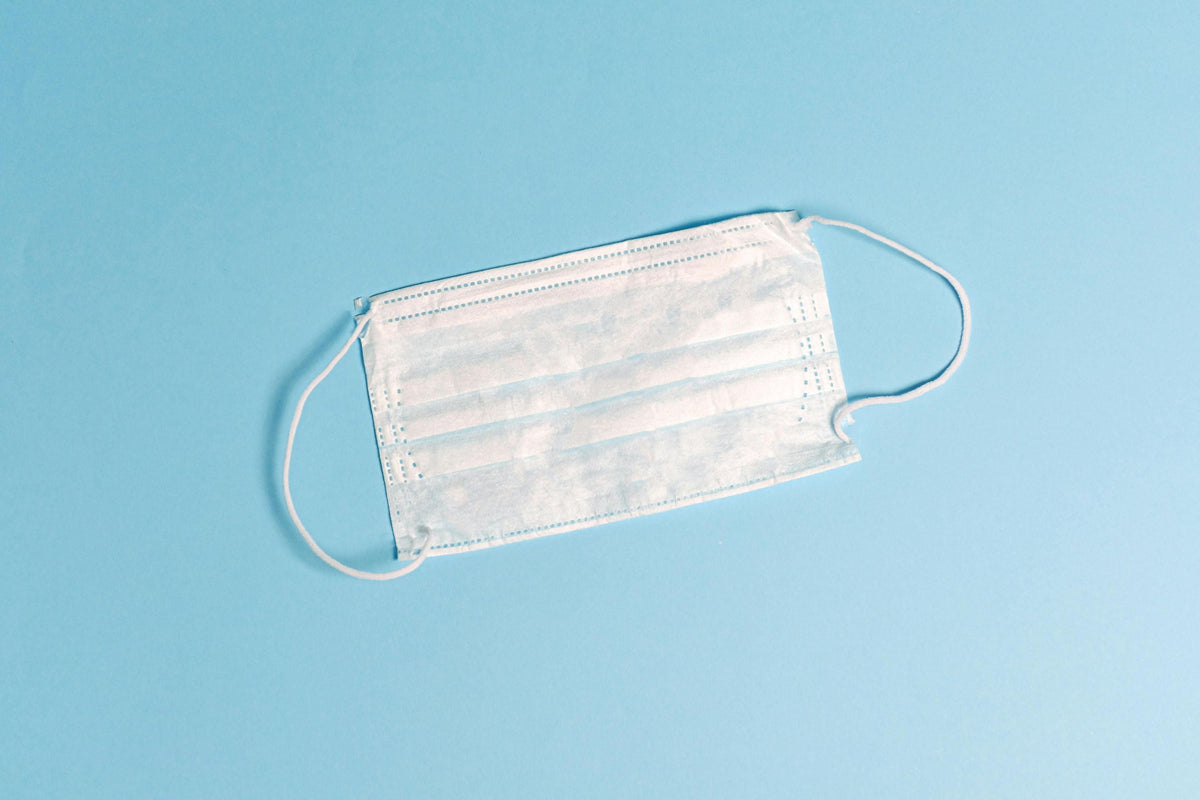 A white medical mask on a blue background.