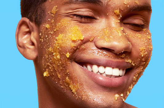 Smiling person with facial treatment against a blue background.