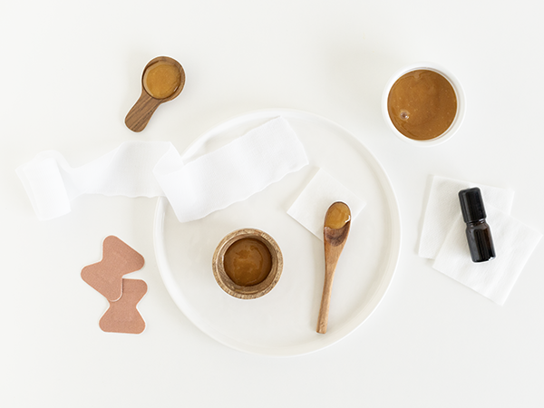 A flat lay of skincare tools and products on a white background.