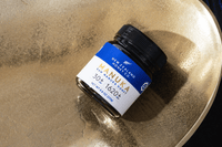 New Zealand Honey Co. Manuka Honey UMF™ 30+ MGO 1620+ jar resting on a gold textured surface
