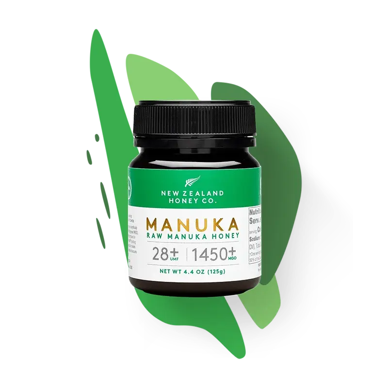 New Zealand Honey Co. Manuka Honey Mini jar UMF™ 28+ MGO 1450+ (green label) on a green paint-splash studio background, 125g (4.4oz)