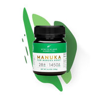 New Zealand Honey Co. Manuka Honey Mini jar UMF™ 28+ MGO 1450+ (green label) on a green paint-splash studio background, 125g (4.4oz)