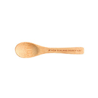 Top-down view of the New Zealand Honey Co. bamboo Daily Spoon engraved with the brand name on a white background