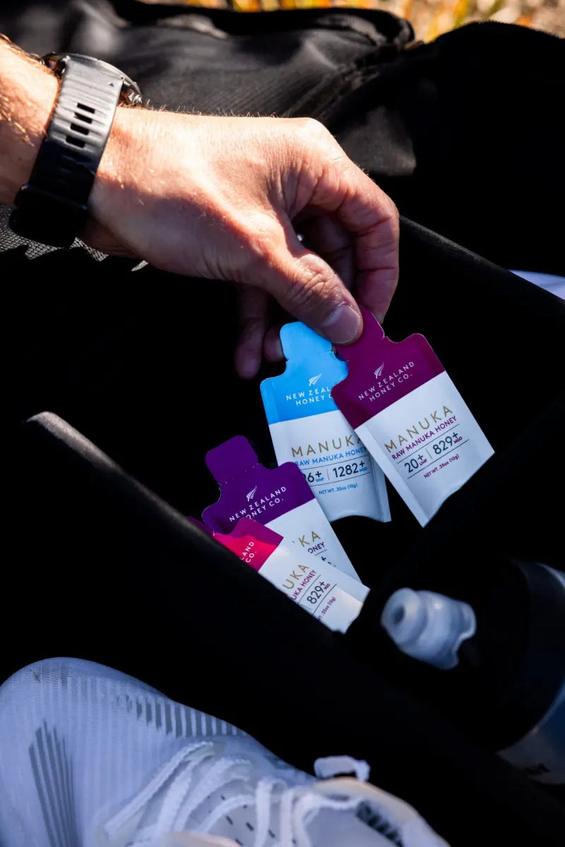 Hand taking Manuka honey single-serve packets from a gym bag