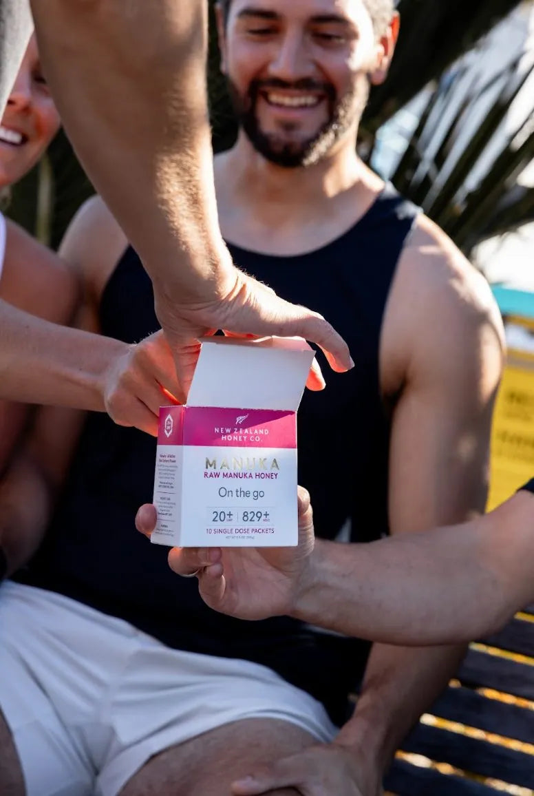 Friends after training sharing a box of UMF™ 20+ single-serve packets